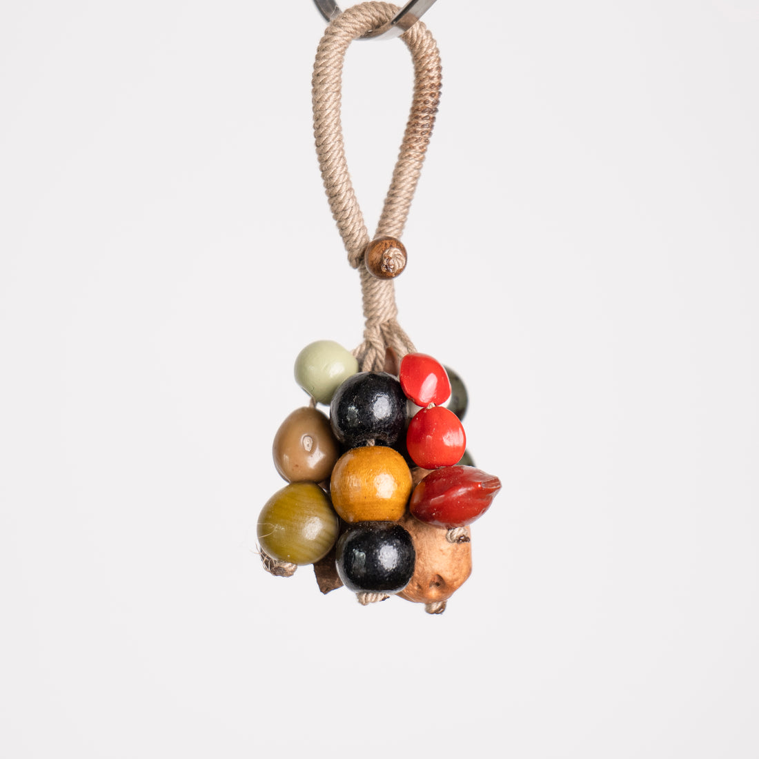 Close-up of Jade Forest seed cluster showing green Bodhi seeds, ivory bead and natural nut shells hand-knotted on hemp rope
