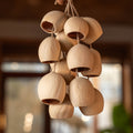 Handcrafted bag charm with 15 cream-colored Phoenix Egg botanical shells and peach pit accent on braided hemp loop — boho nature accessory