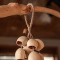 Handcrafted bag charm with 15 cream-colored Phoenix Egg botanical shells and peach pit accent on braided hemp loop — boho nature accessory