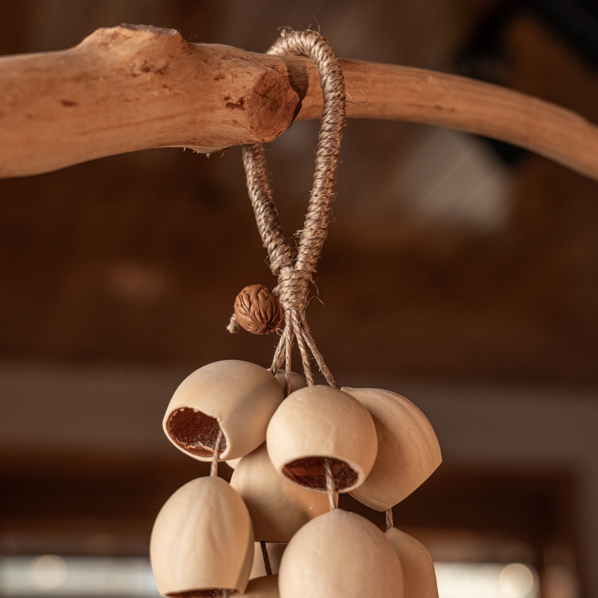Handcrafted bag charm with 15 cream-colored Phoenix Egg botanical shells and peach pit accent on braided hemp loop — boho nature accessory