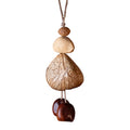Handcrafted 24-element botanical bag charm in two colorways — beige and brown nut shell acoustic accessory for handbags and backpacks
