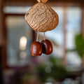 Handcrafted 24-element botanical bag charm in two colorways — beige and brown nut shell acoustic accessory for handbags and backpacks