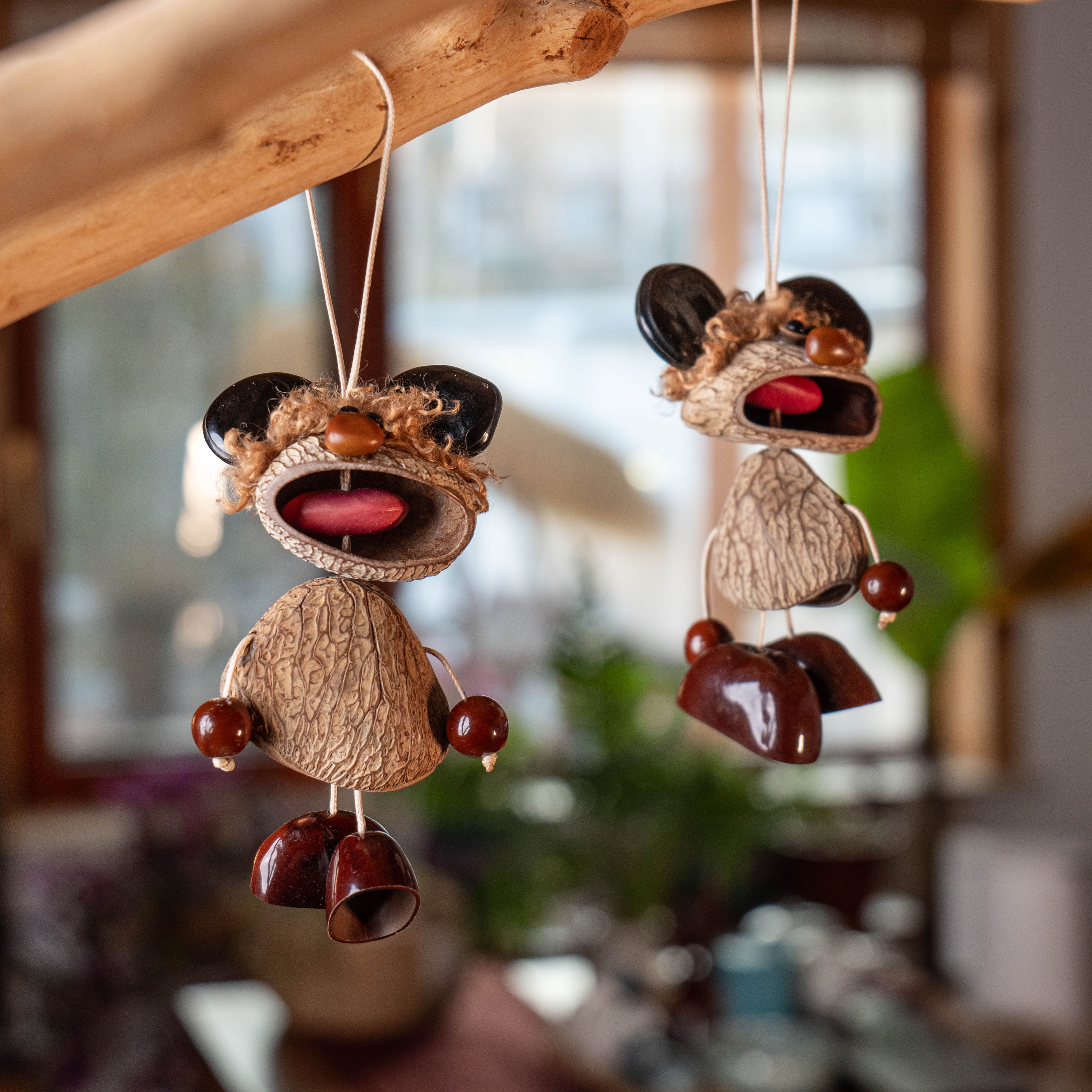 Handcrafted quirky bag charm puppet made from natural nut shells and botanical seeds, featuring a whimsical expression and earthy textures